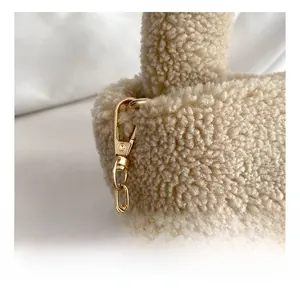 Detail of premium golden metal hook and sherpa texture on minimalist crossbody bag