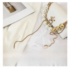 Detail presentation of luxury white leather handbag with pearl handle and gold chain strap