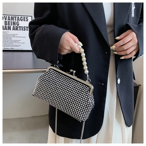 Detail of silver rhinestone evening bag featuring pearl handle and metal clasp closure