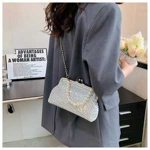 Detail of rhinestone crossbody bag with pearl handle and butterfly accent on model