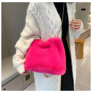 Close-up of hot pink plush crossbody bag with premium metal chain strap detail