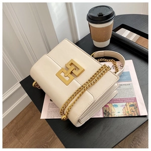 Detail of the vintage cream crossbody bag with a gold geometric metal buckle and chain