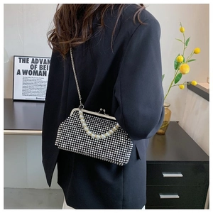 Detailed view of luxury rhinestone shell bag with pearl handle and metal chain strap