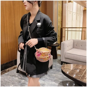 Détail du sac bandoulière rose en forme de basket avec graffiti et chaîne en résine