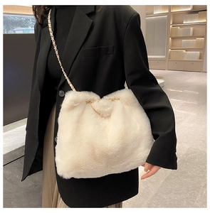 Detail of white faux fur shoulder bag featuring elegant gold chain leather strap