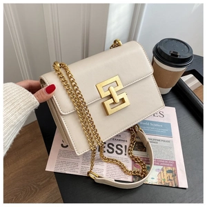 Detail of off-white leather crossbody bag with golden geometric lock and chain strap
