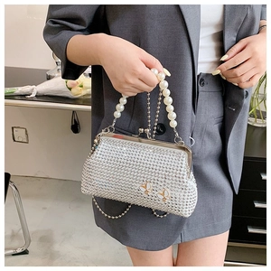 Silver rhinestone evening clutch bag with pearl handle and butterfly accents shown held