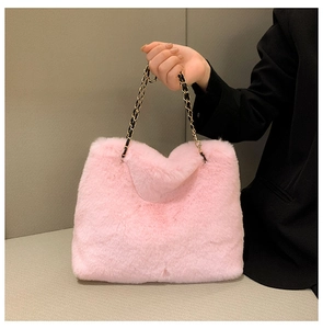 Detail of pink faux fur handbag showing soft texture and gold interwoven chain strap