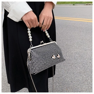 Detail of evening bag featuring silver rhinestones, pearl handle, and butterfly accents
