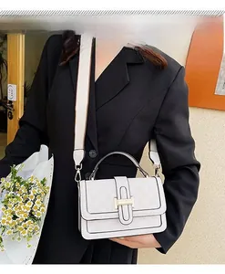 Detail view of cream crossbody bag with H-buckle, checkered texture, and wide fabric strap