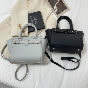 Close-up of pebble leather texture and buckle detail on minimalist Kelly-style handbags