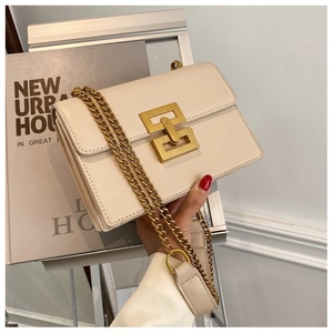Close-up of a stylish beige crossbody bag featuring a golden geometric interlocking clasp