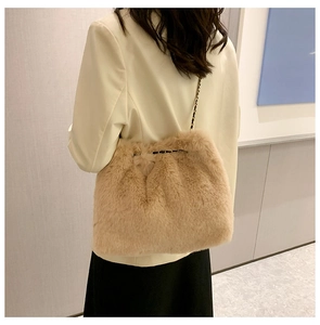 Detail of light brown faux fur shoulder bag with an elegant gold and black chain strap