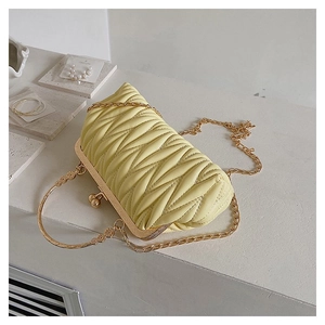 Close-up of quilted cream leather texture with vintage gold ball clasp and chain