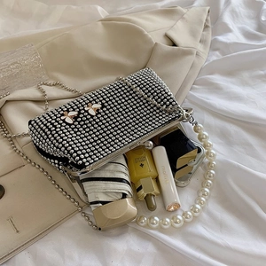 Detail view of black rhinestone clutch with pearl handle and butterfly accents for women