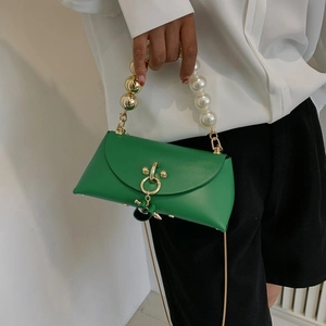 Detail of green leather handbag featuring pearl handle and gold ring closure