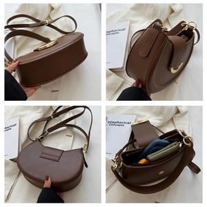 Detail view of dark brown saddle bag showing gold clasp, adjustable strap and interior capacity