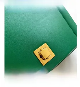 Détail du sac en cuir vert avec fermoir rotatif doré et surpiqûres de haute qualité