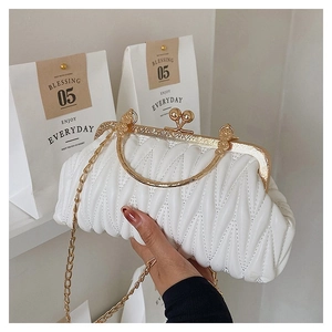 Detail of white pleated clutch with V-shaped quilting and vintage gold metal clasp