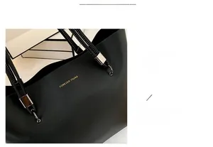 Detail of black tote bag showing textured synthetic leather and gold Forever Young text