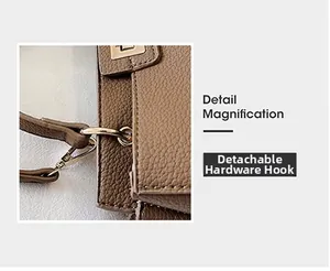 Dettaglio del gancio rimovibile in metallo dorato su una borsa in pelle marrone martellata