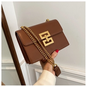 Close-up of vintage brown leather crossbody bag with bold gold geometric metal lock buckle