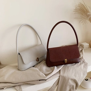 Detail of minimalist retro handbags in grey and brown leather with metallic gold clasps