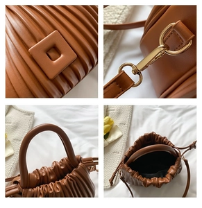 Detail view of brown pleated texture handbag with gold hardware and stylish handle