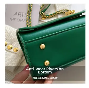 Vue détaillée du fond du sac en cuir vert avec clous de protection en métal doré