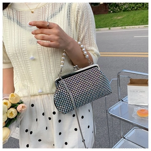 Detail of colorful rhinestone evening bag with elegant pearl handle and metal chain strap