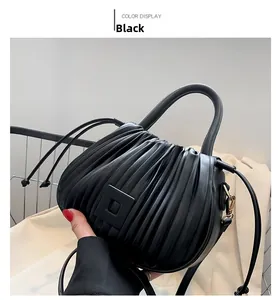 Close-up of black pleated bucket bag with square buckle and metal strap hooks