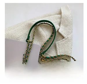 Gros plan sur la bandoulière en cuir vert émeraude avec chaîne en métal doré tissé