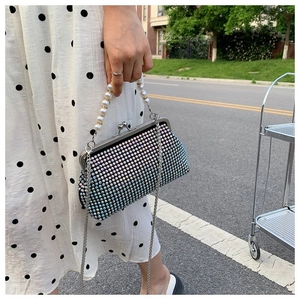 Detail of luxury rhinestone handbag with pearl handle and silver chain strap for women