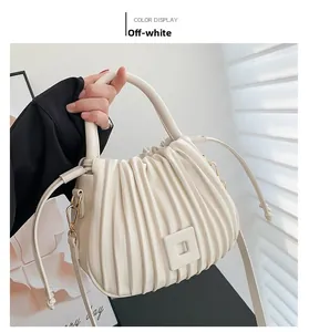 Detail of off-white pleated bucket bag with square buckle and round top handle