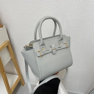 Elegant light blue litchi grain leather handbag with gold hardware and shoulder strap