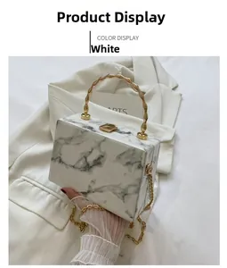 Detail of white marble acrylic box bag with golden bamboo handle and chain strap