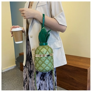 Détail du sac bandoulière ananas avec texture matelassée verte et détails dorés