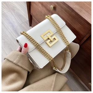 Close-up of white leather crossbody bag with gold chain strap and square metal buckle