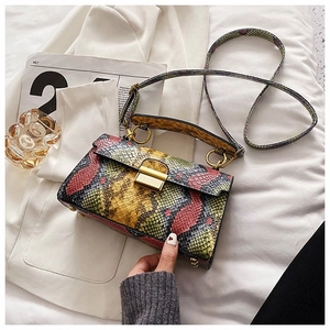 Close-up of vibrant snakeskin pattern bag with golden metal clasp and cross-body strap