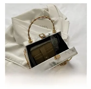 Detail showing the interior capacity of a white marble texture box bag with accessories