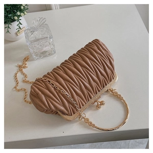 Detail of tan ruched leather evening clutch with vintage gold floral metal handle