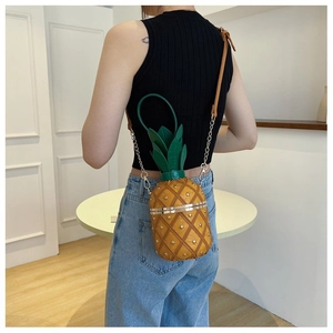 Détail du sac à bandoulière en forme d'ananas avec rivets métalliques et texture matelassée