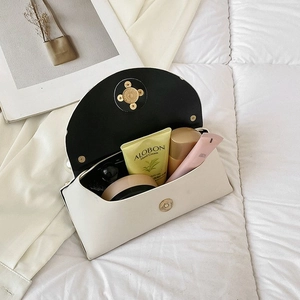 Detail view of the cream leather handbag interior showing storage space and gold magnetic closure