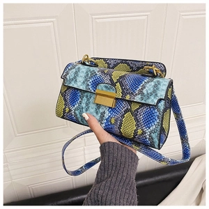 Detail of blue and green snakeskin crossbody bag with golden rectangular clasp closure