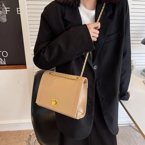 Détail d'un sac à main chic en cuir abricot avec fermoir doré et bandoulière chaîne