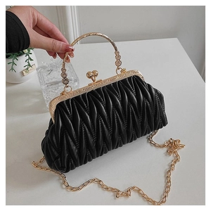 Macro detail of black matelassé leather bag with vintage gold clasp and chain