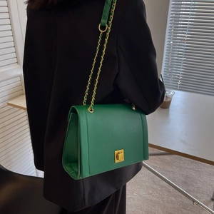 Gros plan du sac bandoulière vert vintage avec fermoir doré et bandoulière chaîne