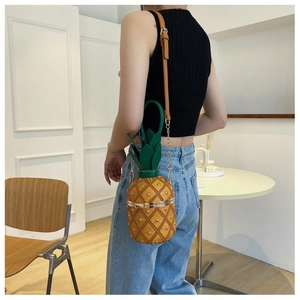 Gros plan détaillé d'un sac à bandoulière en forme d'ananas avec des clous dorés