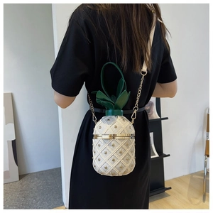Vue détaillée du sac bandoulière en forme d'ananas avec motif matelassé et clous dorés