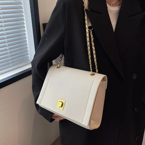 Gros plan sur le sac bandoulière blanc à chaîne avec un fermoir rotatif doré élégant